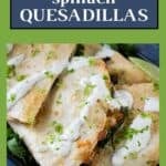 Side shot of multiple bean and cheese quesadillas garnished with fresh herbs and crema on a black plate with a lime wedge on the side.