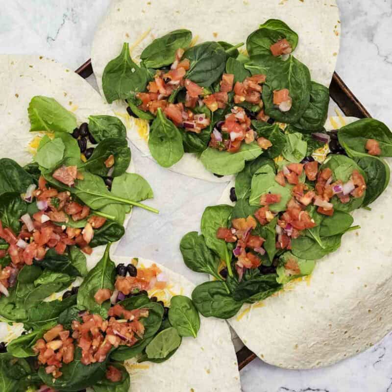 Overhead view of process shot 2 - layer on the spinach and then the pico de gallo.