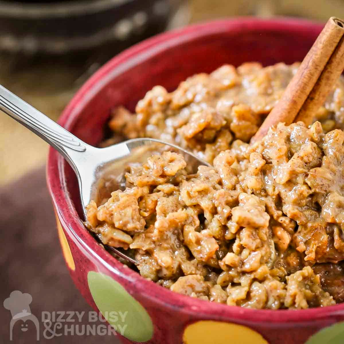 Side close up shot of instant coffee oatmeal in a red bowl with green and yellow polka dots with a spoon taking a scoop.