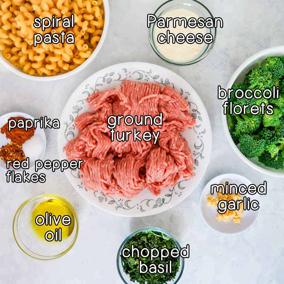 Ingredients for ground turkey pasta dinner - ground turkey, pasta, broccoli, Parmesan, garlic, basil, olive oil, red pepper flakes, and paprika.