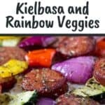 Close up overhead view of kielbasa and veggies on a parchment paper-lined baking sheet.