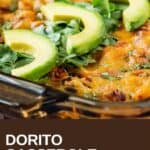Side close up shot of dorito casserole in pan lined with chopped cilantro and slices of avocado.