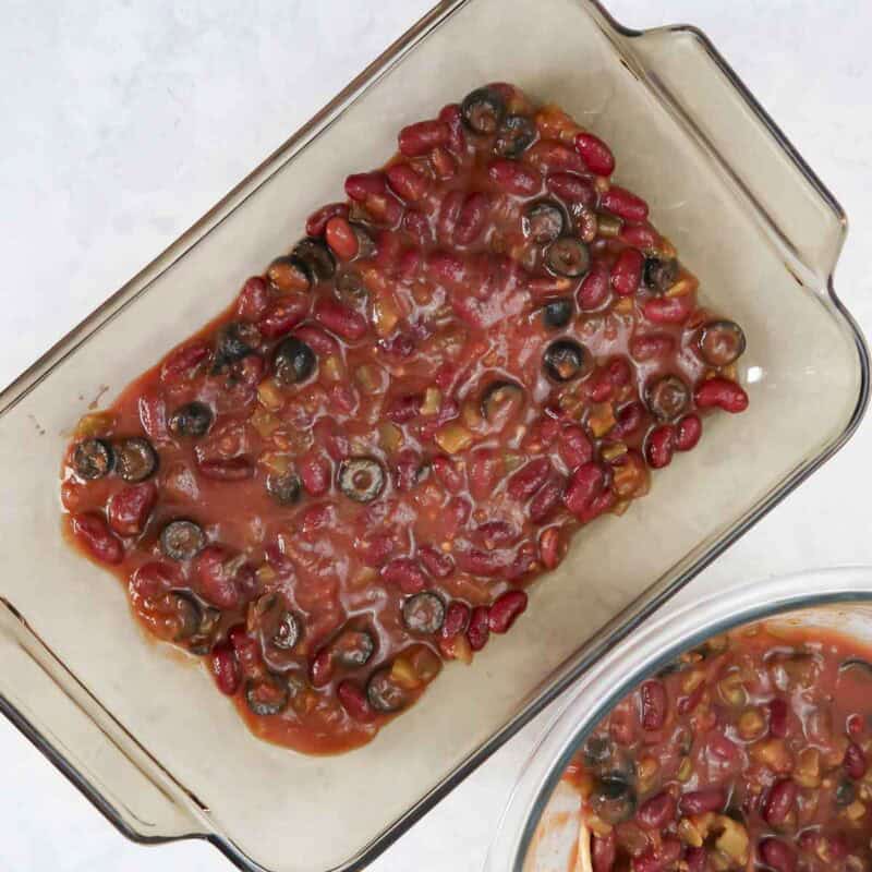 Overhead view of process shot 2 - place half the sauce in the bottom of an 8 x 11 inch baking dish.