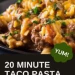 Side close up shot of taco pasta on a black plate garnished with fresh herbs with more herbs in the background.