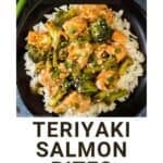 Overhead shot of teriyaki salmon and broccoli on a bed or rice garnished with fresh green onions on a black plate with more green onions on the side.