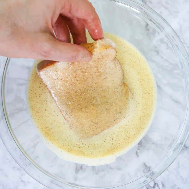 Overhead view of process shot 3 - pour into a bowl large enough to fit a piece of the bread. Dip a slice of bread in the banana-egg mixture, coating it entirely.