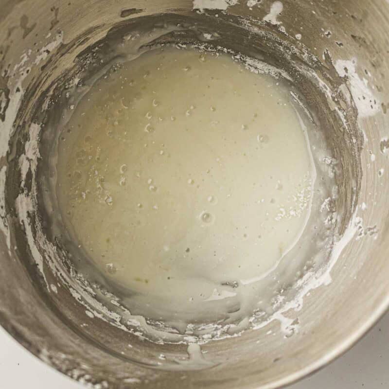 Overhead view of process shot 6 - in a small bowl, whisk together the powdered sugar and lemon juice until smooth and pourable.