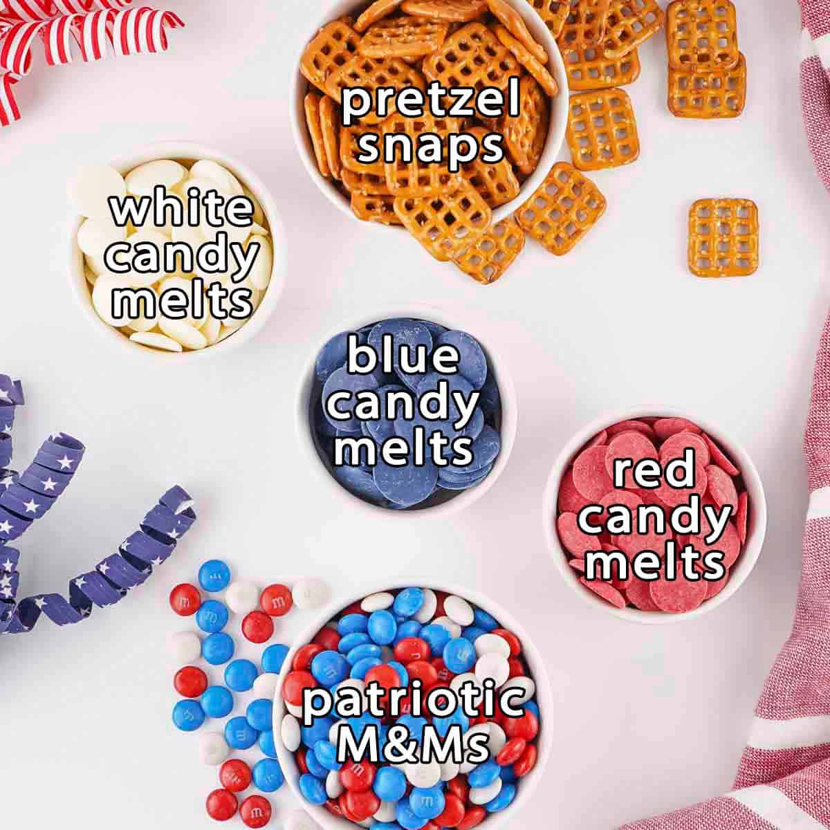 Overhead shot of ingredients - pretzel snaps, white candy melts, blue candy melts, red candy melts, and patriotic M&Ms.