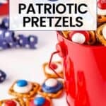 Side shot of patriotic pretzels in a red bucket with blue ribbon and red and blue buckets in the background.