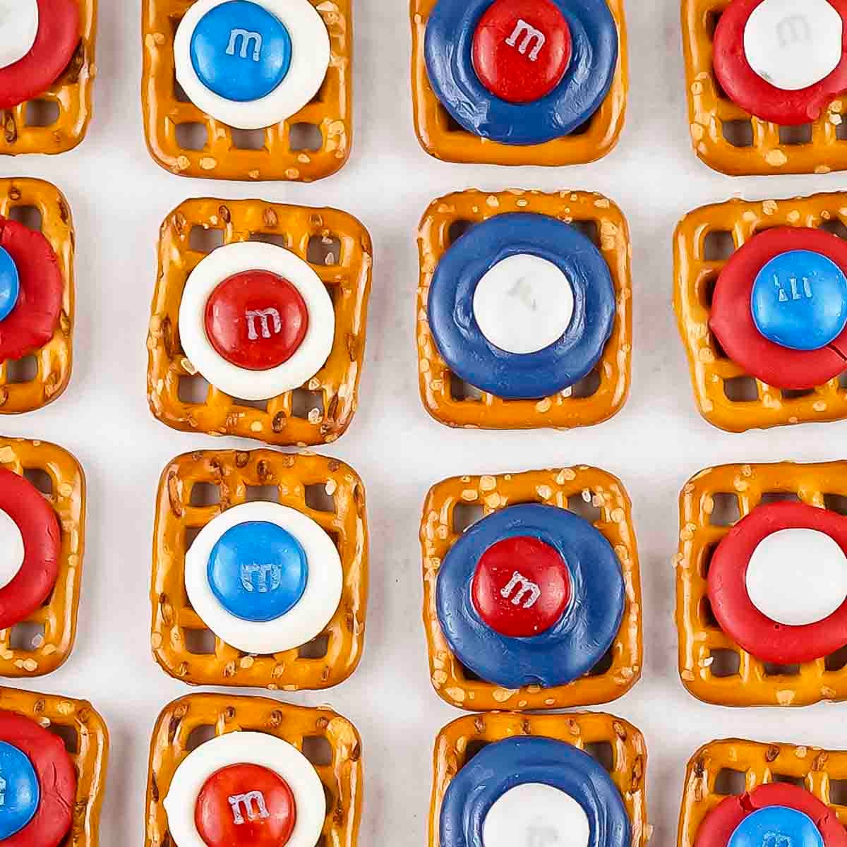 Close up shot of patriotic pretzels lined up on a baking sheet lined with parchment paper.