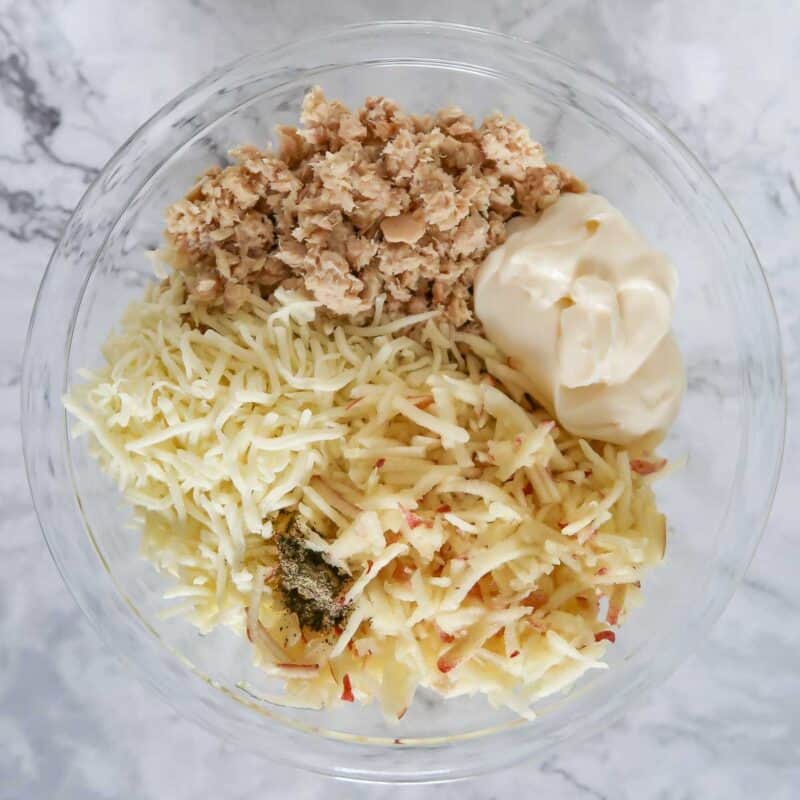 Overhead view of process shot 1 - combine the salmon, cheese, mayonnaise, apple, and pepper in a bowl and mix well.