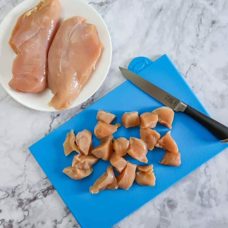 Overhead view of process shot 1 - cut the chicken into bite-sized cubes.