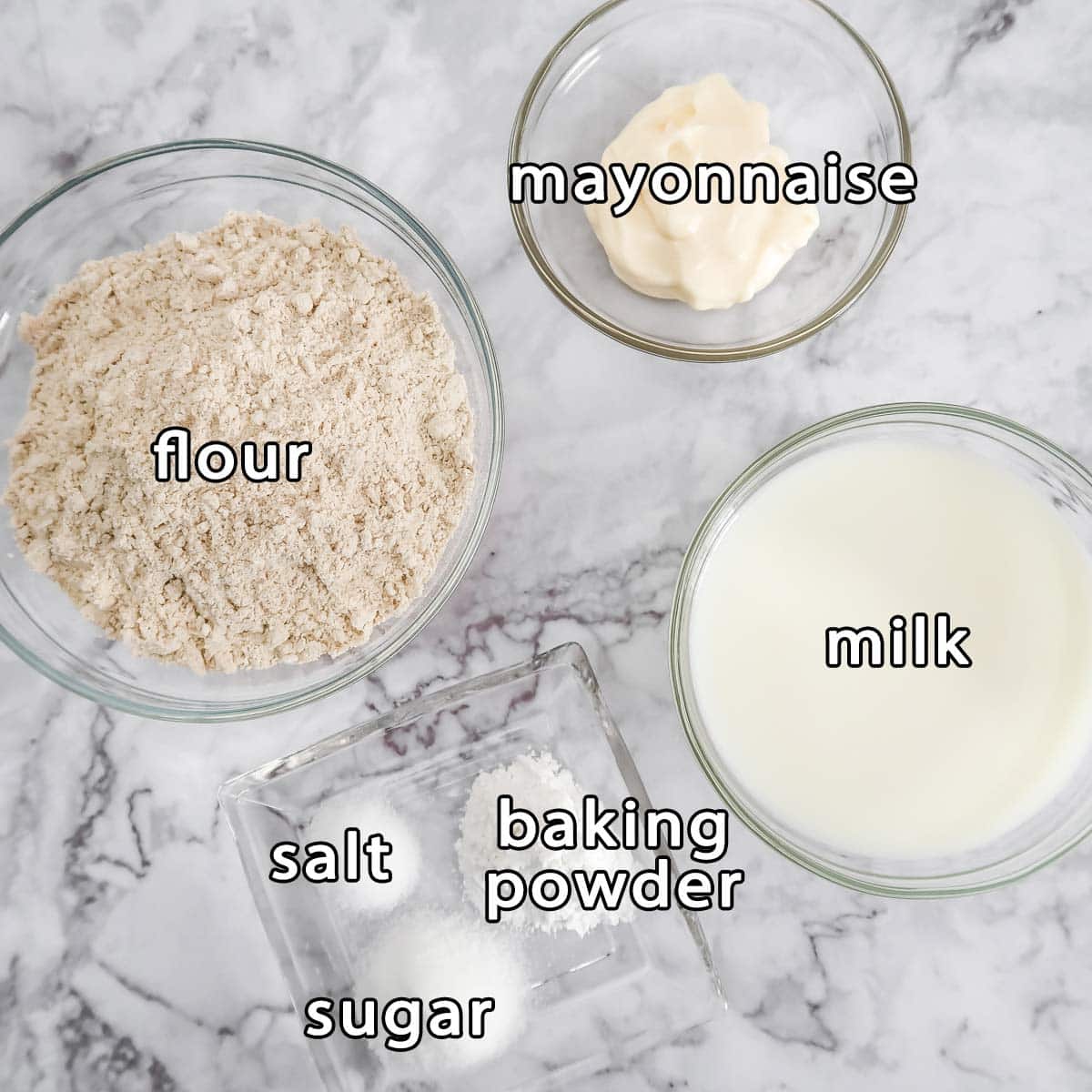 Overhead shot of ingredients - mayonnaise, flour, milk, baking powder, sugar, and salt.