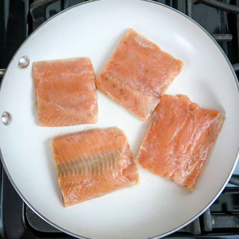 Overhead view of process shot 2 - spray a little nonstick spray in a large skillet and warm over medium heat. Add the salmon fillets to the skillet.