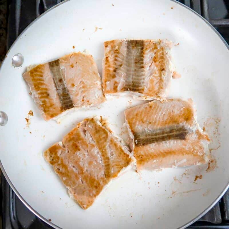 Overhead view of process shot 3 - cook the salmon fillets until lightly browned (about 2 minutes on each side).