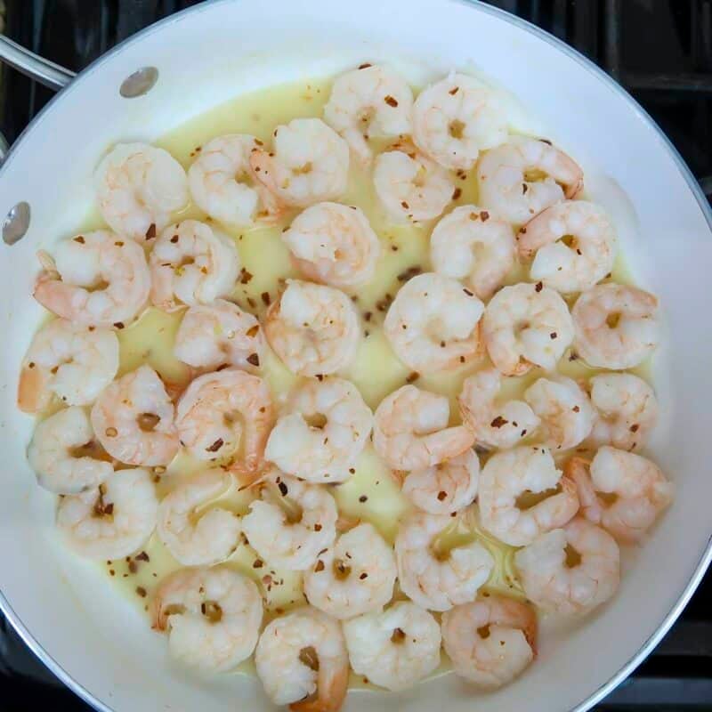 Overhead view of process shot 2 - cook the shrimp until they are almost done, then add the lime juice and red pepper flakes. Cook about 2 more minutes until they are fully cooked.