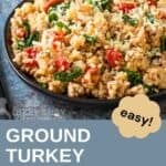 Side shot of couscous and ground turkey on a black plate with fresh herbs in the background.