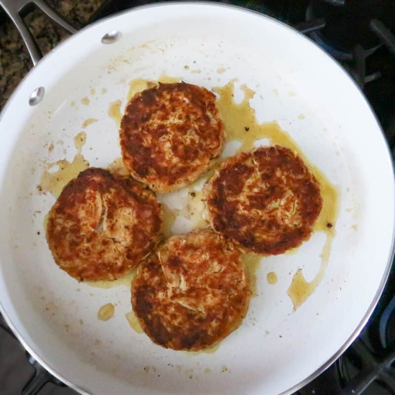 Overhead view of process shot 3 - heat butter in a skillet over medium-high heat. Cook the patties on each side until browned, about 5 minutes.