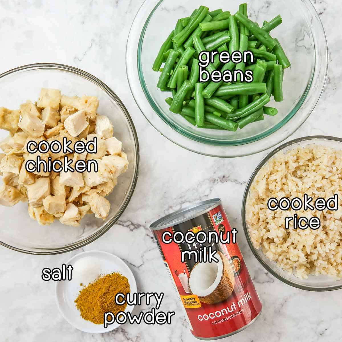Overhead shot of ingredients - green beans, cooked chicken, cooked rice, coconut milk, curry powder, and salt.