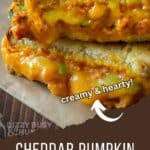 Side shot of two halves of pumpkin grilled cheese stacked on a piece of wax paper.