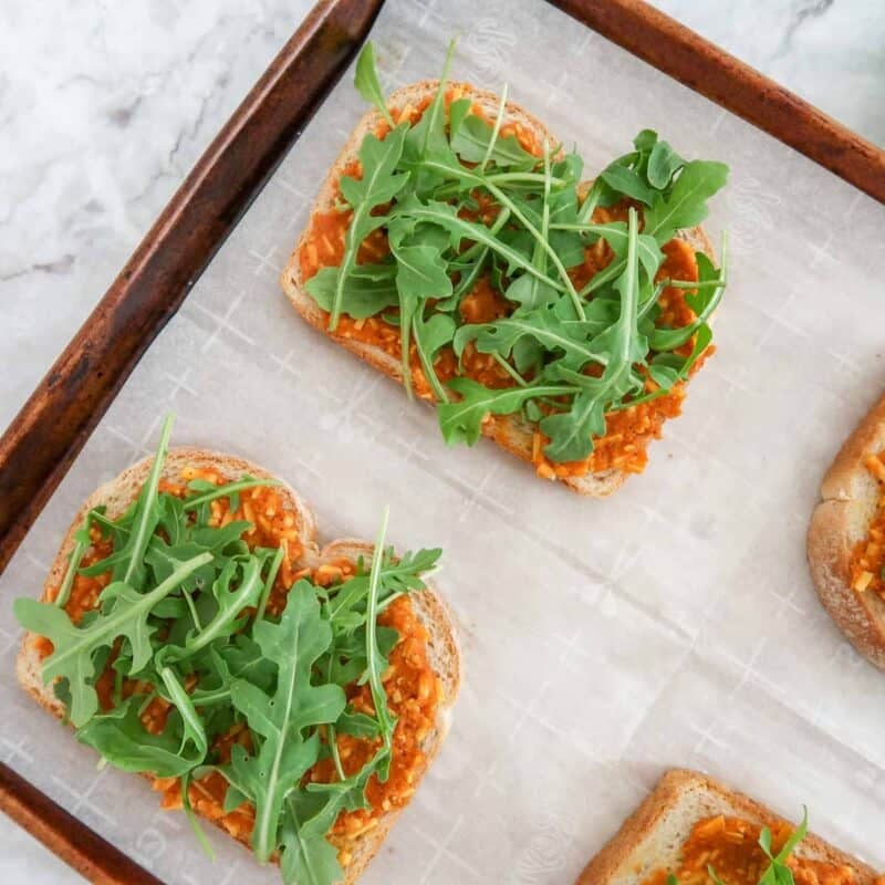 Overhead view of process shot 3 - top with a small handful of arugula.