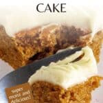 Side shot of a fork taking a piece of pumpkin spice cake with cream cheese frosting off of a white speckled plate.