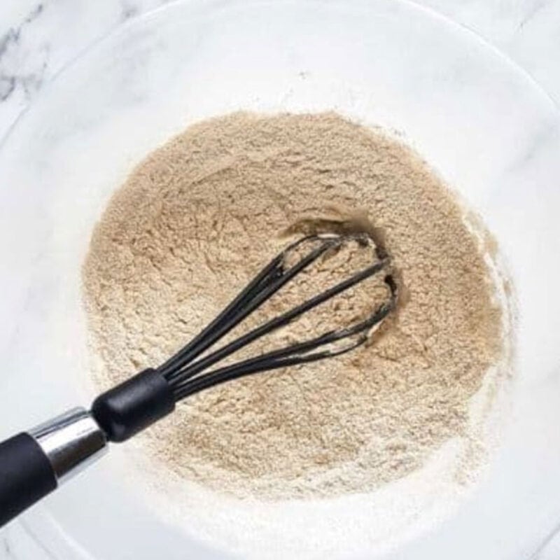 Overhead view of process shot 1 - combine the flour, baking soda, salt, and baking powder in a bowl.