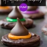 Close up of a witch hat cookie with orange and green icing on a baking sheet.