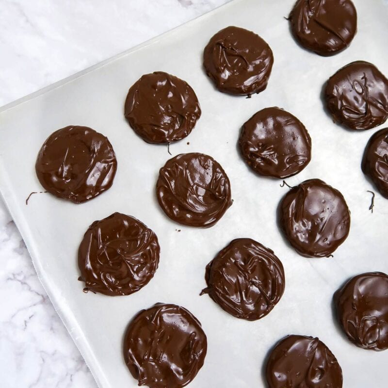 Overhead view of process shot 2 - Place a sheet of wax paper on a cookie sheet or other flat tray. Dip each round cookie or cracker in the chocolate, scrape off the excess, and place on the wax paper. Refrigerate until the chocolate hardens.