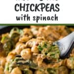 Close up shot of a fork holding up a bite of marry me chickpeas and spinach over a full black plate of the meal.