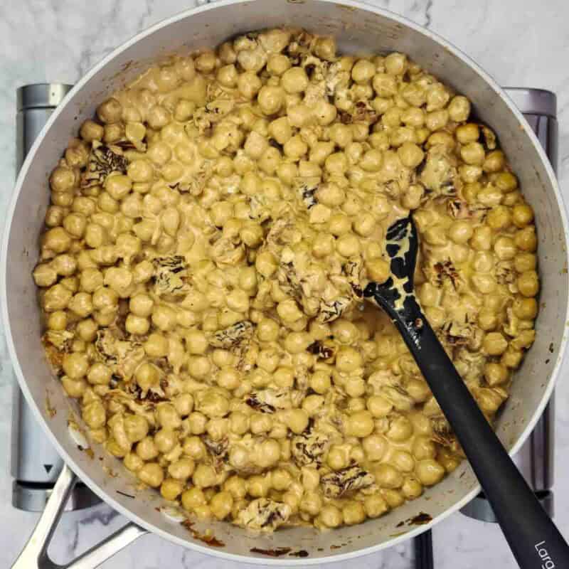 Overhead view of process shot 3 - reduce the heat to low, then stir in the cream cheese continuously until it melts into a rich, creamy sauce.